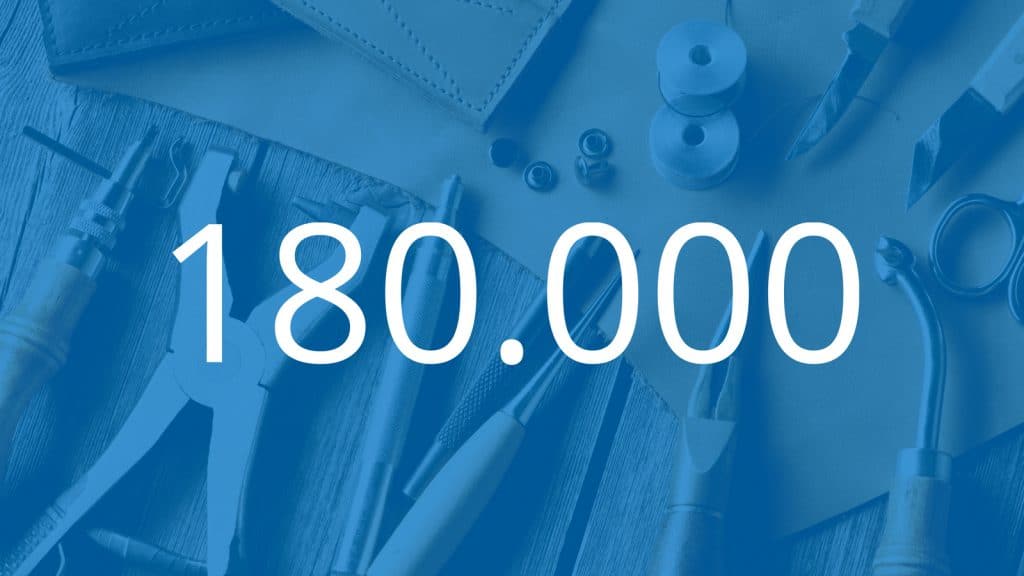 Mesa cheia de ferramentas por detrás de um primeiro plano azul, com a inscrição do número 180 000