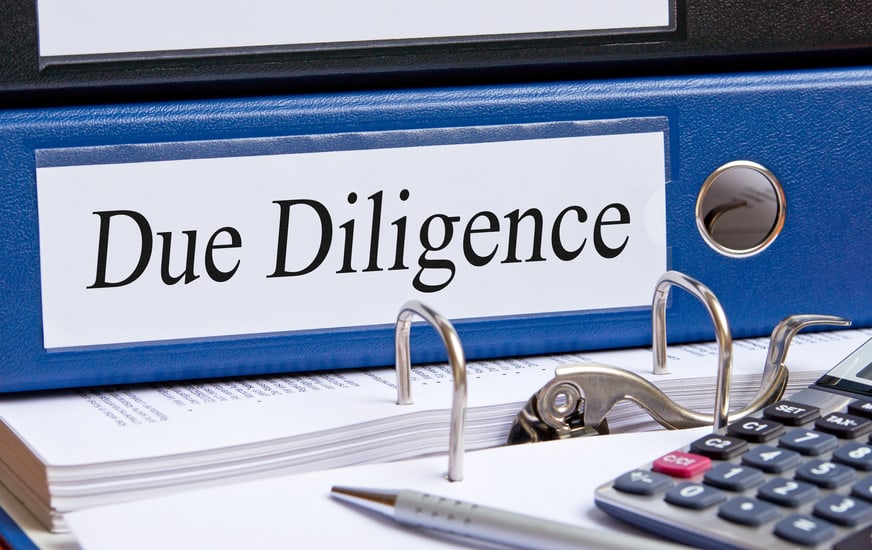 Zdjęcie niebieskiej teczki z napisem "Due Diligence".