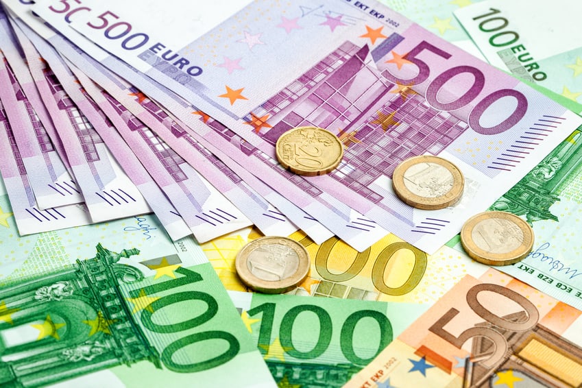 Száz és ötszáz eurós bankjegyek érmékkel egy asztalon