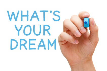 Kéz ír egy kék filctollal a táblára: Mi az Álmod?