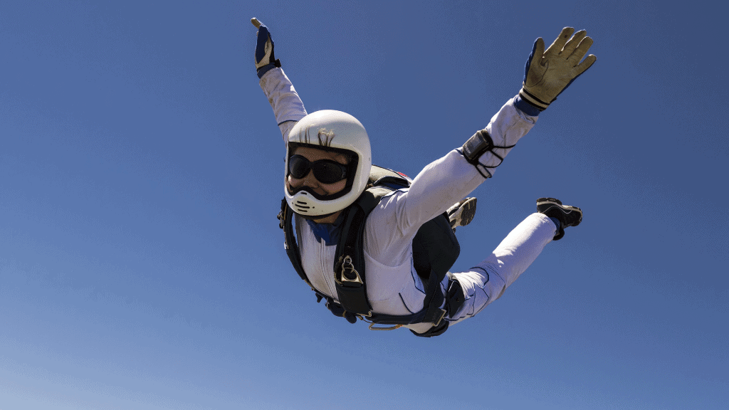A skydiver flying with arms and legs raised without an open parachute