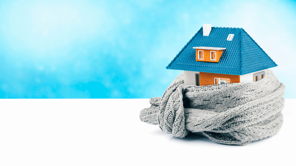 A toy house is wrapped in a warm scarf.
